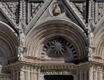 Portail principal  En haut du portail, un saint présente une maquette de la ville